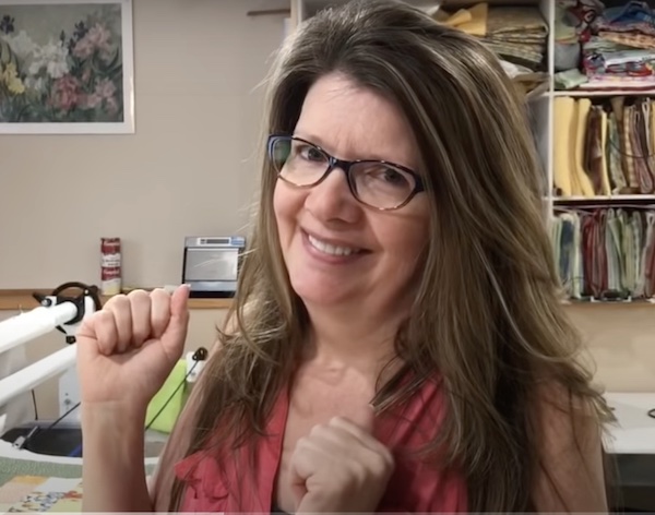 Paola Jo in a video class making a quilt and smiling.