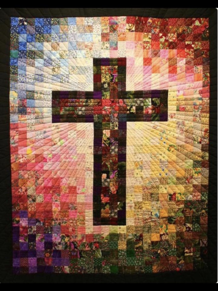 Cross of Many Squares quilt in many different colors with a cross in the middle.