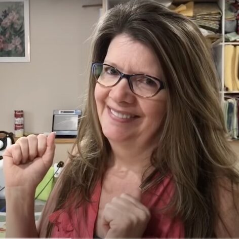 Paola Jo in a video class making a quilt and smiling.